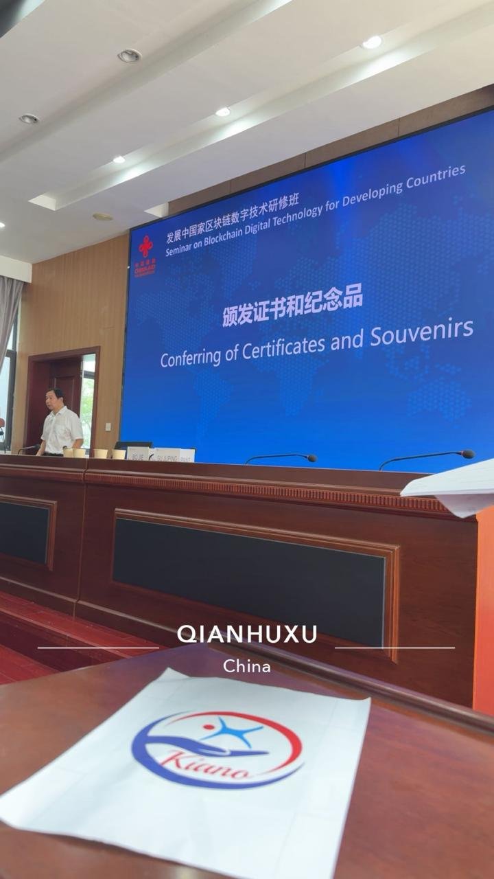 Conferring of certificates session at the seminar, with the KIANO logo on the desk in the foreground
