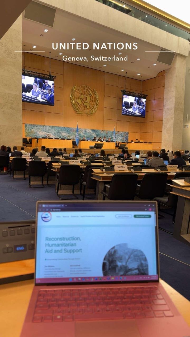 Assembly hall of the United Nations in Geneva during a session, with a laptop showing KIANO materials in the foreground