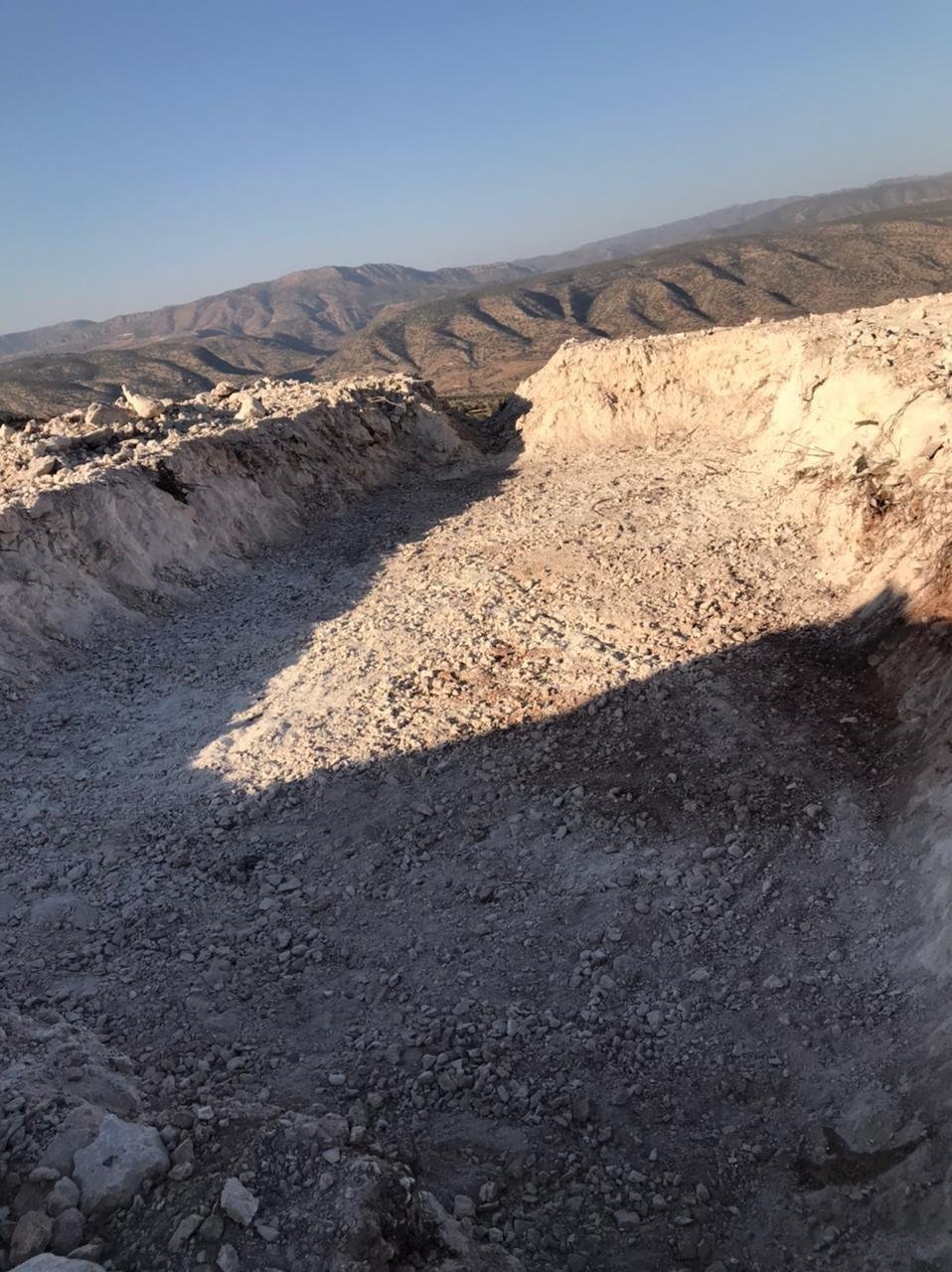 A new access road cut through rocky hillside above a valley near Duhok