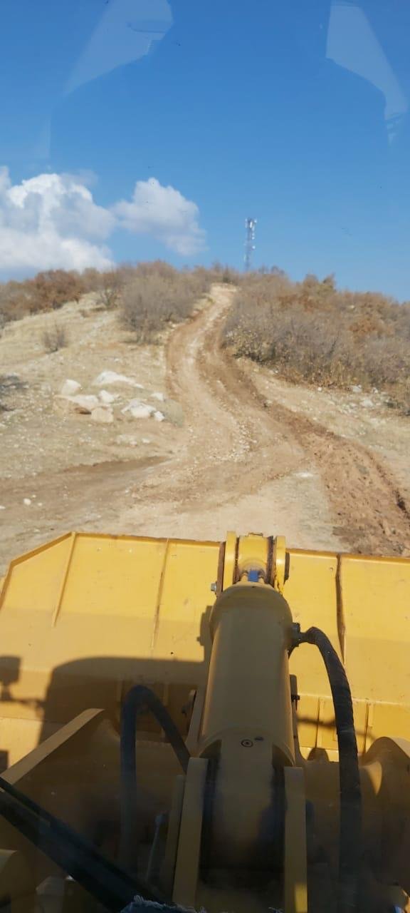 View from the cab of a bulldozer grading a village track uphill