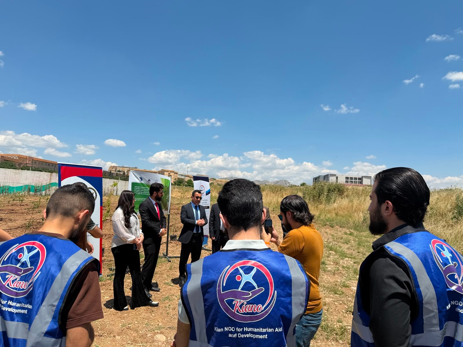 KIANO volunteers in branded vests at a tree-planting event at the University of Duhok